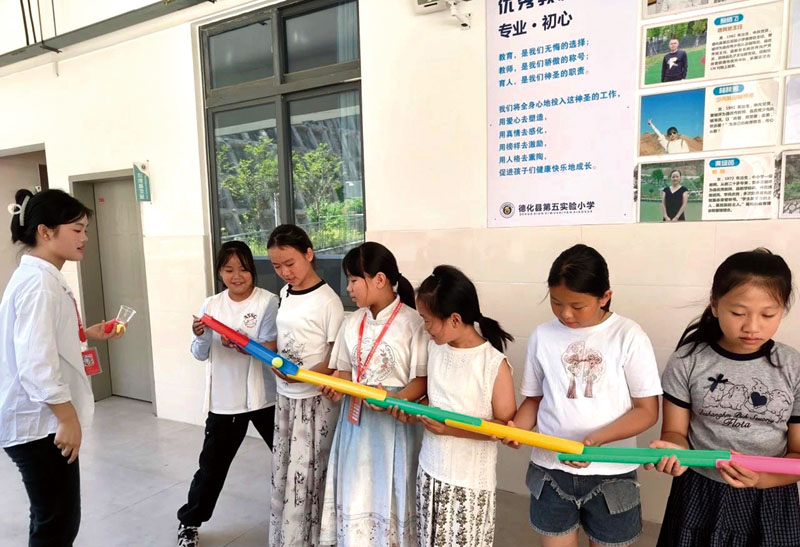 参加职工子女暑托班的小朋友们在老师指导下制作UV管传送乒乓球.jpg