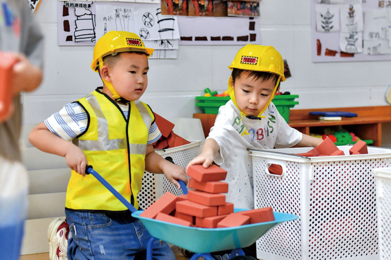 城关幼儿园暑期留园班里，小朋友在“砖注大师”区域玩搬砖.jpg